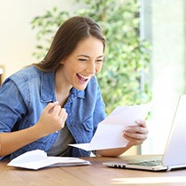 Woman looking at a piece of paper and celebrating