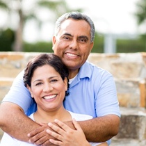 An older couple smiling outside.