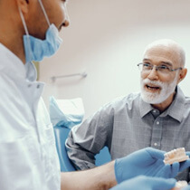a patient speaking with his dentist about implant dentures