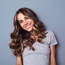 Woman smiling after visiting emergency dentist in Astoria