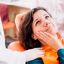 Dentist explaining cost of treating dental emergencies in Astoria