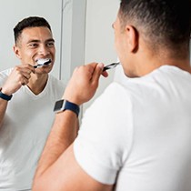Man brushing his teeth to prevent dental emergencies in Astoria