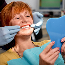 An older woman examining her smile.