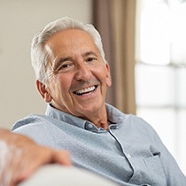 happy elderly man sitting on a couch 