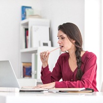 Woman chewing on her pencil while working