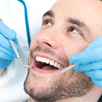 Man completing dental checkup with an implant dentist in Astoria