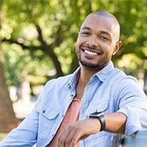 smiling man sitting among nature 