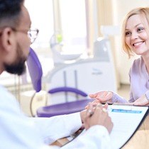 smiling woman talking to her dentist