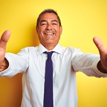 person smiling and holding two thumbs-up