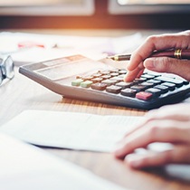 Business professional adding up numbers on calculator