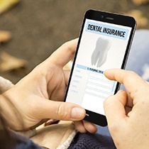 Woman looking at dentist insurance on phone