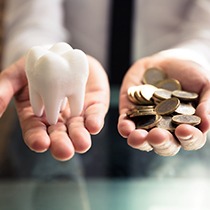 Person holding tooth in one hand and money in the other