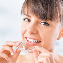 Woman placing her Invisalign tray