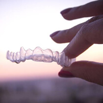 Hand holding Invisalign tray