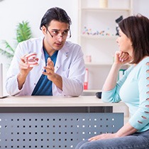 Dentist explaining cost of tooth-colored fillings and crowns in Astoria