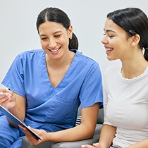 Female patient talking to dental staff member