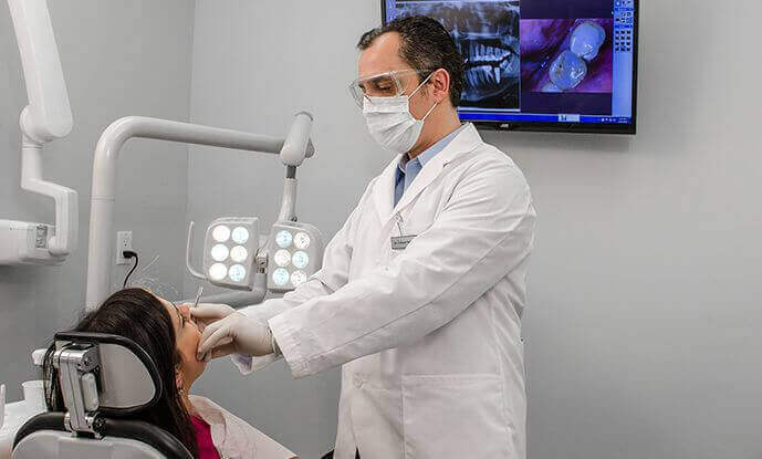 Dr. Shkurti examining patient with dental tools