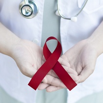 Dentist holding a maroon ribbon