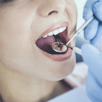 Dentist checking mouth of female