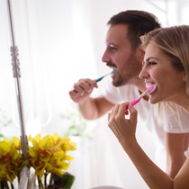 Man and woman brushing teeth