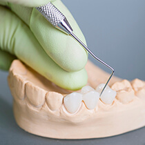 Astoria Restorative Dentistry person prodding model teeth