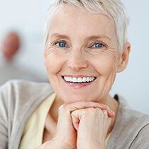 Elderly lady holding hands together smiling