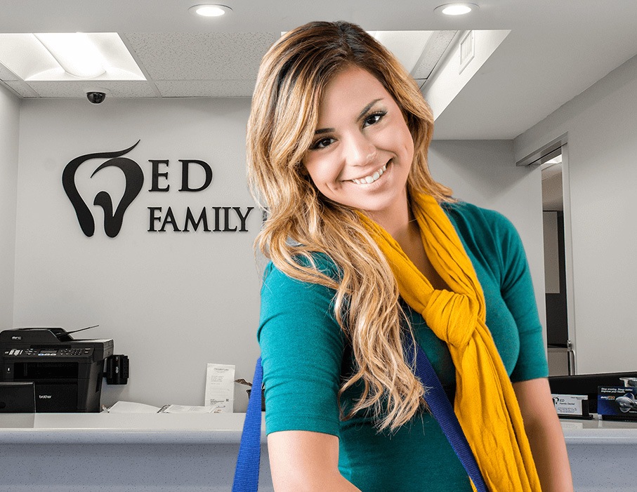 Lady in teal smiling in Astoria dental office