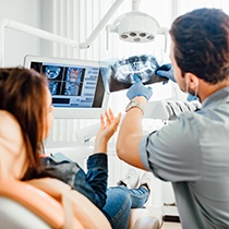 a dentist pointing to an X-ray