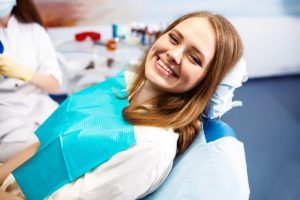 person smiling while sitting in dentist's chair