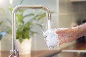 Filling glass with tap water according to recommendations from a dentist in Astoria