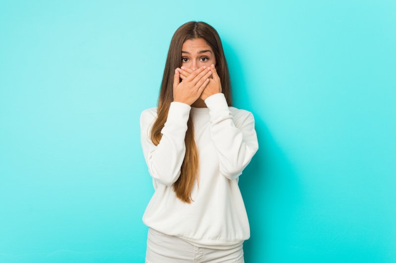 Woman covering her smile with her hands