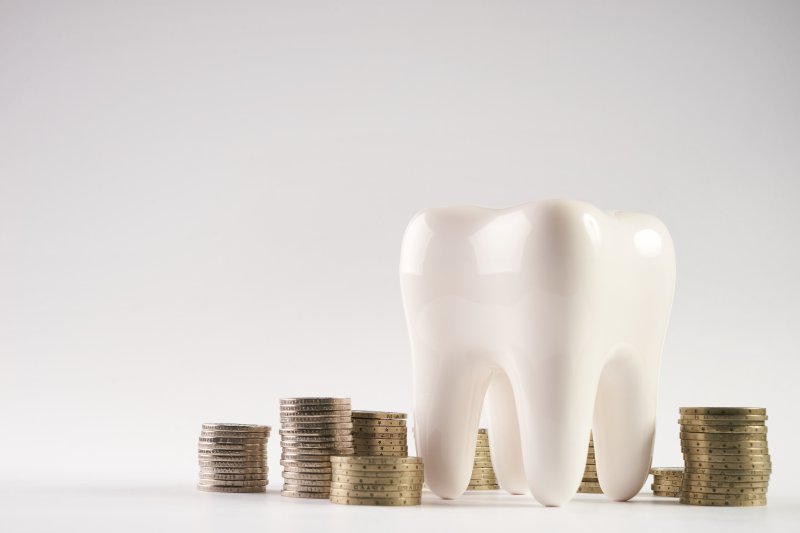 Model of a tooth surrounded by stacks of coins