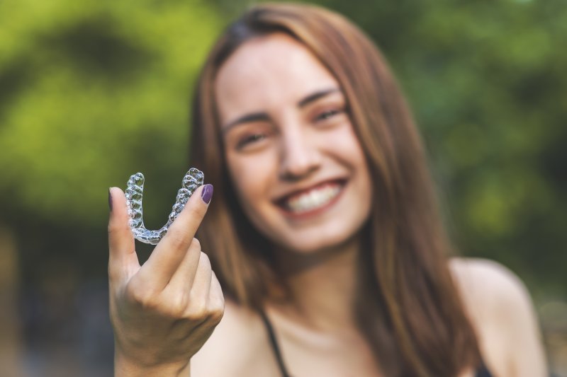 Woman holding an Invisalign aligner