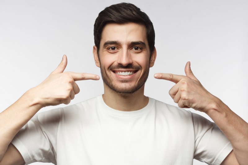 man showing off dental implants in Astoria
