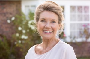 an older woman smiling with dental implants