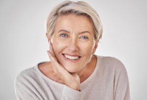 an older woman smiling with Invisalign