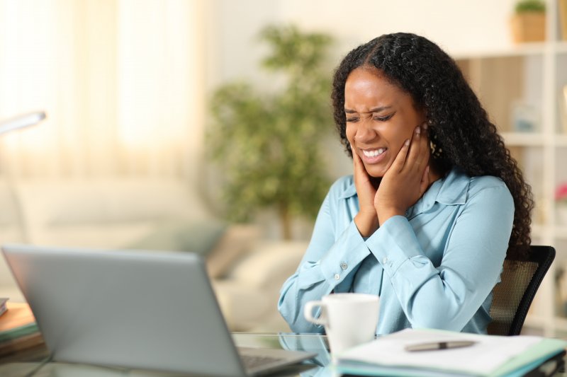 An African American woman suffering from TMJ disorder
