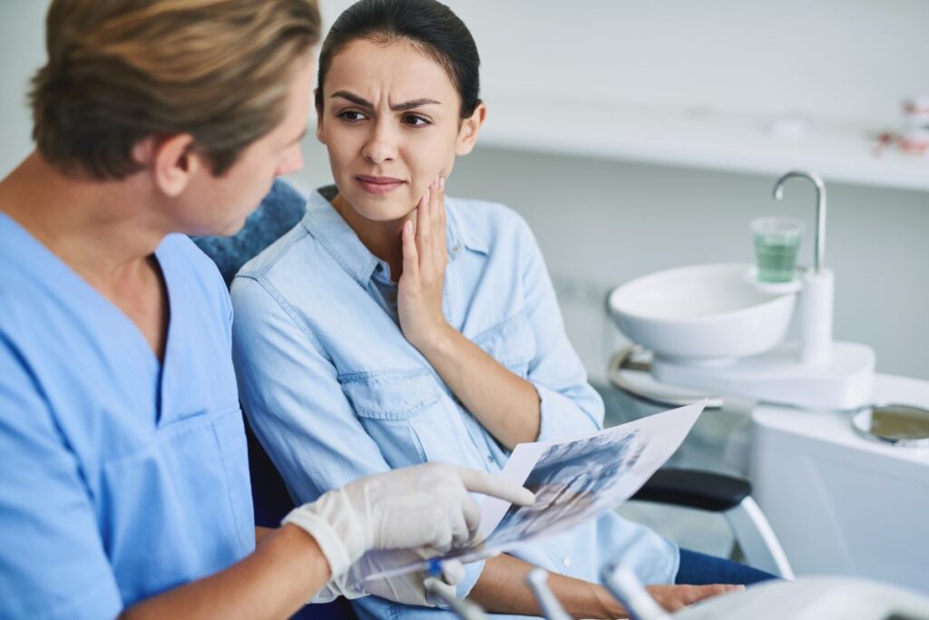 A woman discussing jaw pain with her dentist
